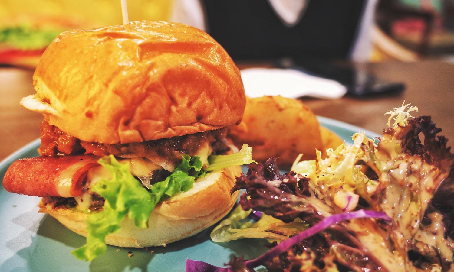 A burger and salad on a plate.