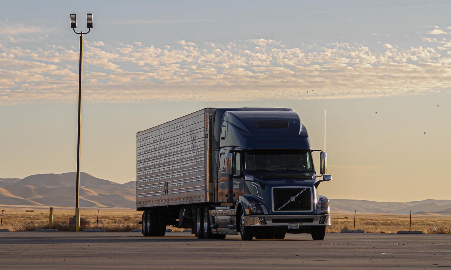 A truck sitting alone in a parking lot at dusk. 