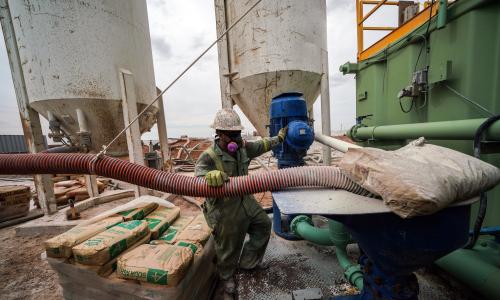 A man in an oxygen mask works on an oil rig. 