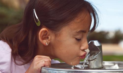 Girl drinking from water fountain