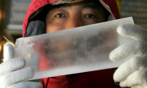 A scientist holds out a cylinder of ice.