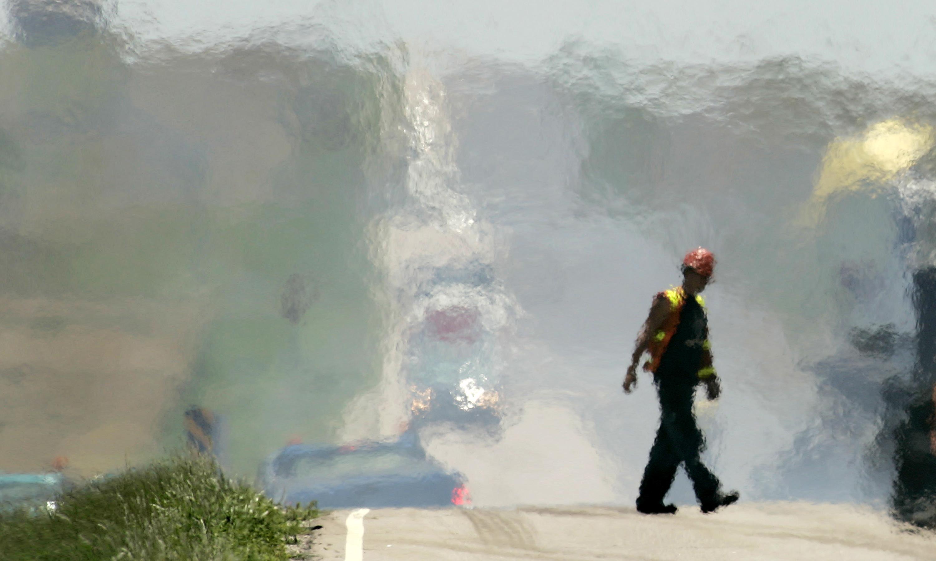 A road worker walks through blistering heat