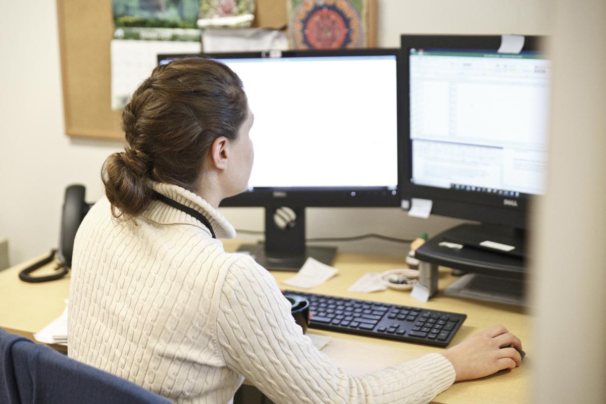 Person works at a desk, on a computer.